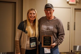 HRBO Executive Director Janelle Long Presenting Volunteer Russ Edmonds Lifetime Achievement Award